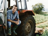 Farmer Sitting on a Tractor in a Field